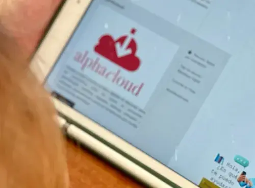 Persona usando una tablet que muestra la plataforma AlphaCloud en pantalla.